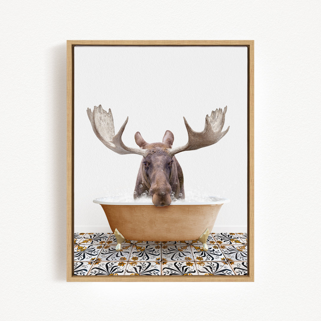A moose with large antlers is sitting in a bathtub filled with water, creating a whimsical and humorous scene.