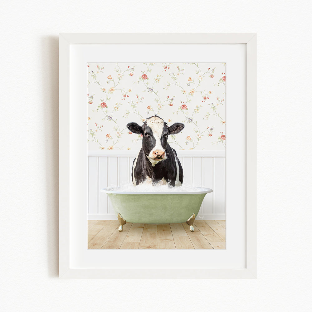 A black and white cow is sitting in a green bathtub filled with water, creating a whimsical and humorous scene.