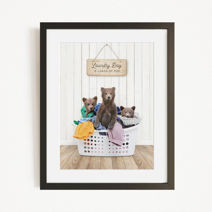 A framed image depicting three bears sitting in a laundry basket, with a sign above them that reads "Laundry Day is loads of fun".