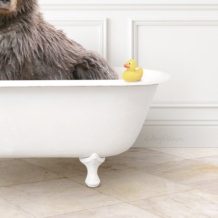 A large brown bear sits in a white bathtub, with a yellow rubber duck resting on the edge of the tub.