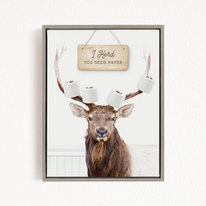 A deer with antlers wearing a sign that says "I herd you need paper"