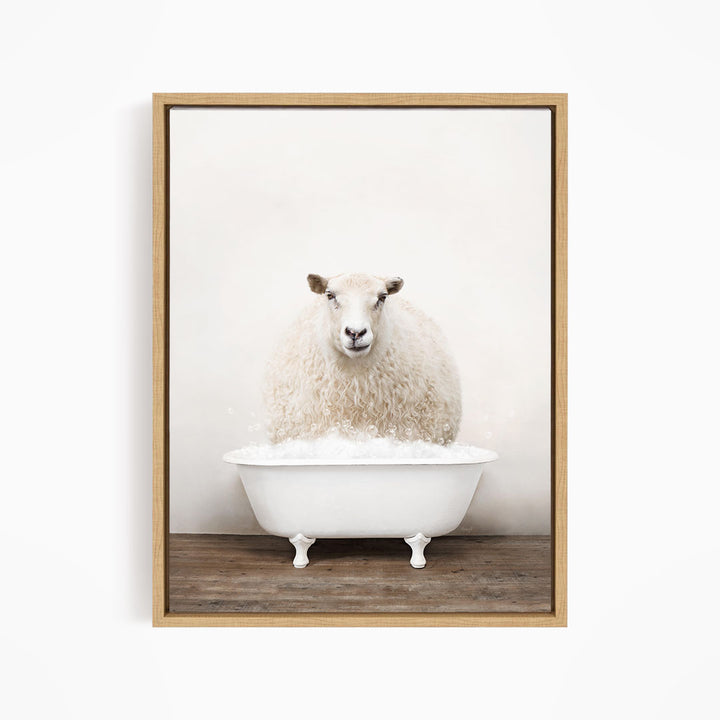 A fluffy white sheep sits in a white bathtub filled with bubbles, looking directly at the camera.