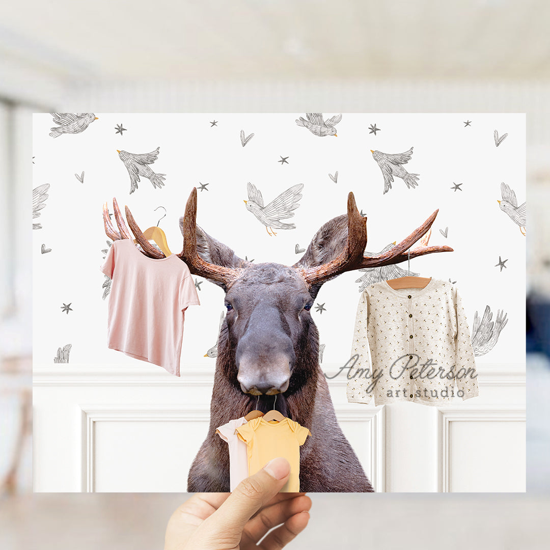 a hand holding a piece of food in front of a picture of a moose