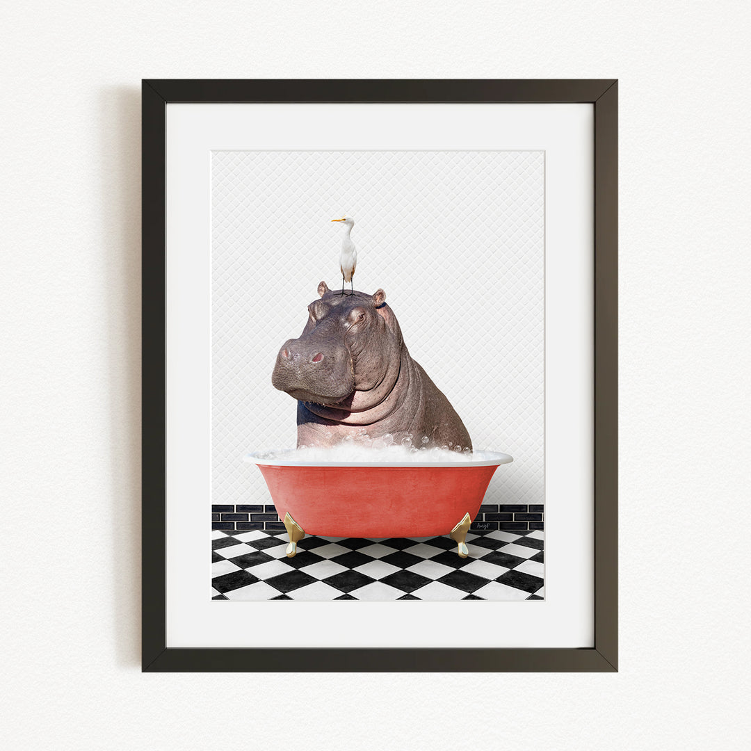 A framed image depicting a large hippopotamus sitting in a red bathtub, with a white bird perched on its head.