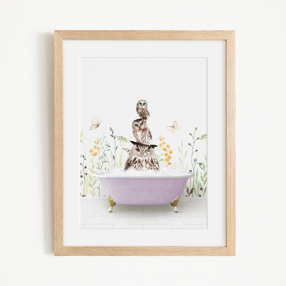 A framed print depicting a whimsical scene of a cat sitting in a bathtub, surrounded by flowers and butterflies.