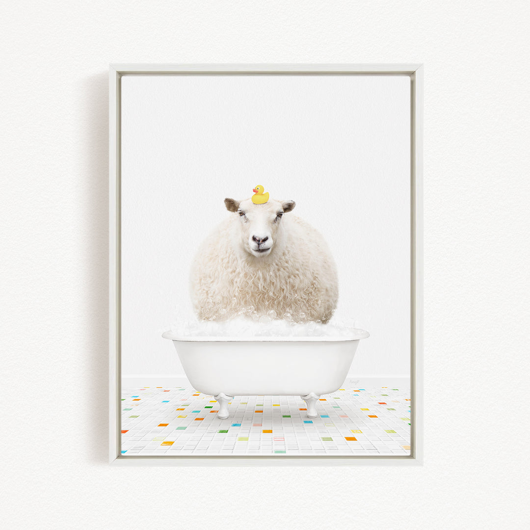 A fluffy white sheep sits in a white bathtub filled with bubbles, with a yellow rubber duck perched on its head.
