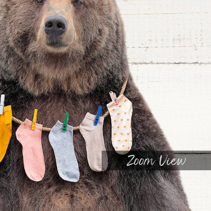 A large brown bear wearing a clothesline with colorful socks hanging on it.