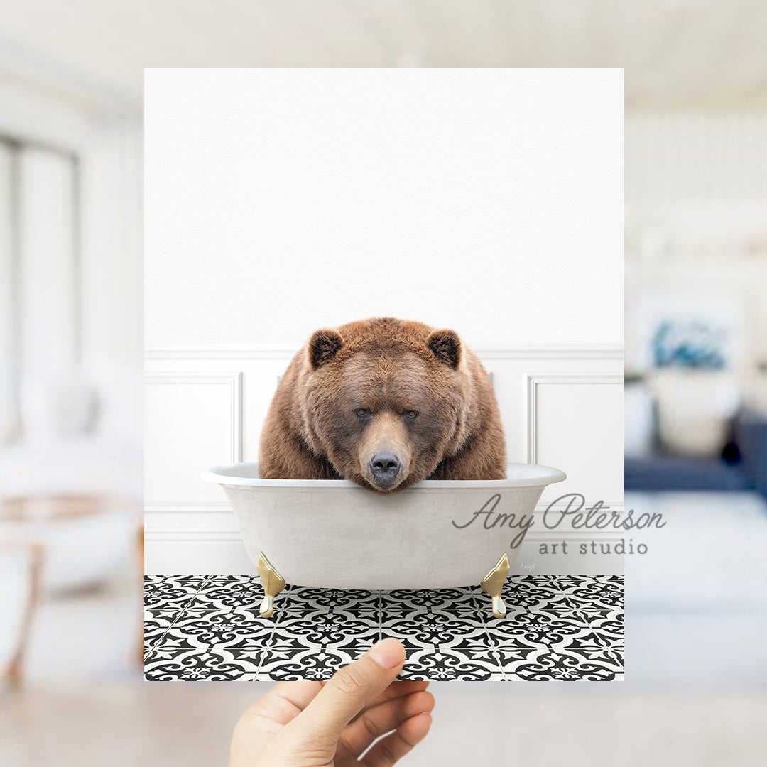 a person holding up a picture of a bear in a bathtub