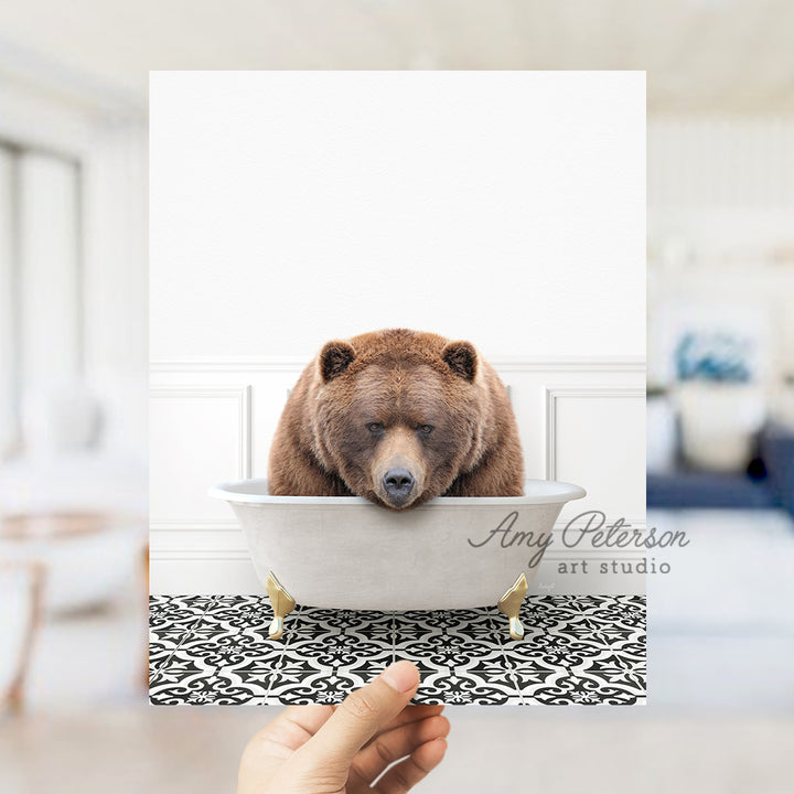 a person holding up a picture of a bear in a bathtub