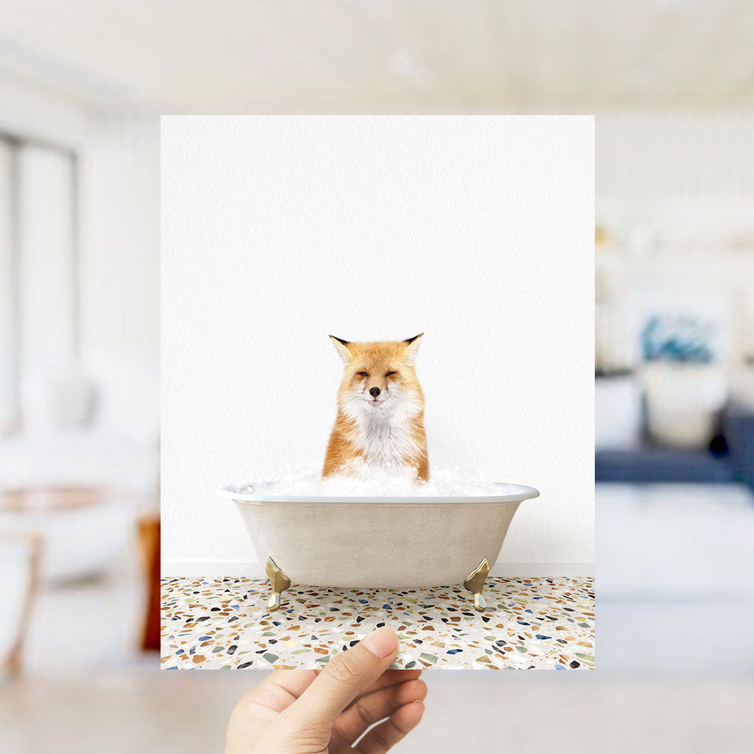 A red fox is sitting in a white bathtub filled with water, looking directly at the camera.