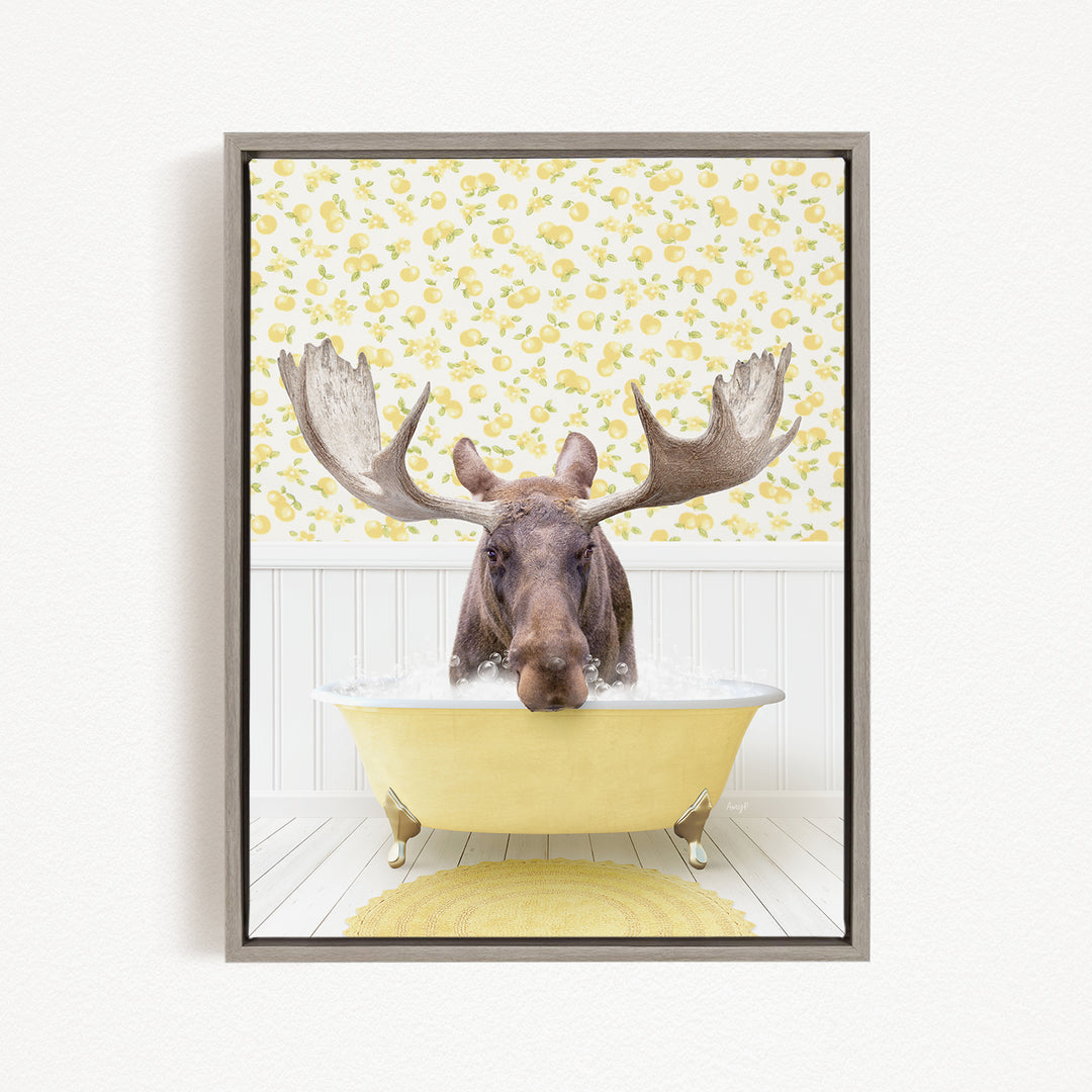 A moose with large antlers is sitting in a yellow bathtub, surrounded by a yellow and white floral pattern on the wall behind it.