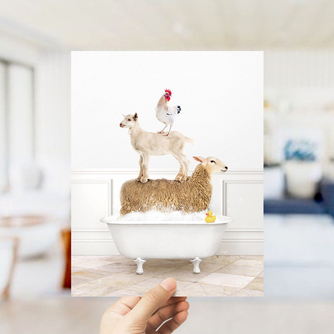 A hand holds up a framed image depicting a goat standing on a sheep's back while a chicken stands on the sheep's head.