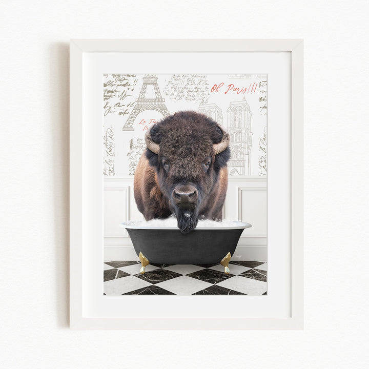 A buffalo is sitting in a bathtub, with a Paris-themed background behind it.