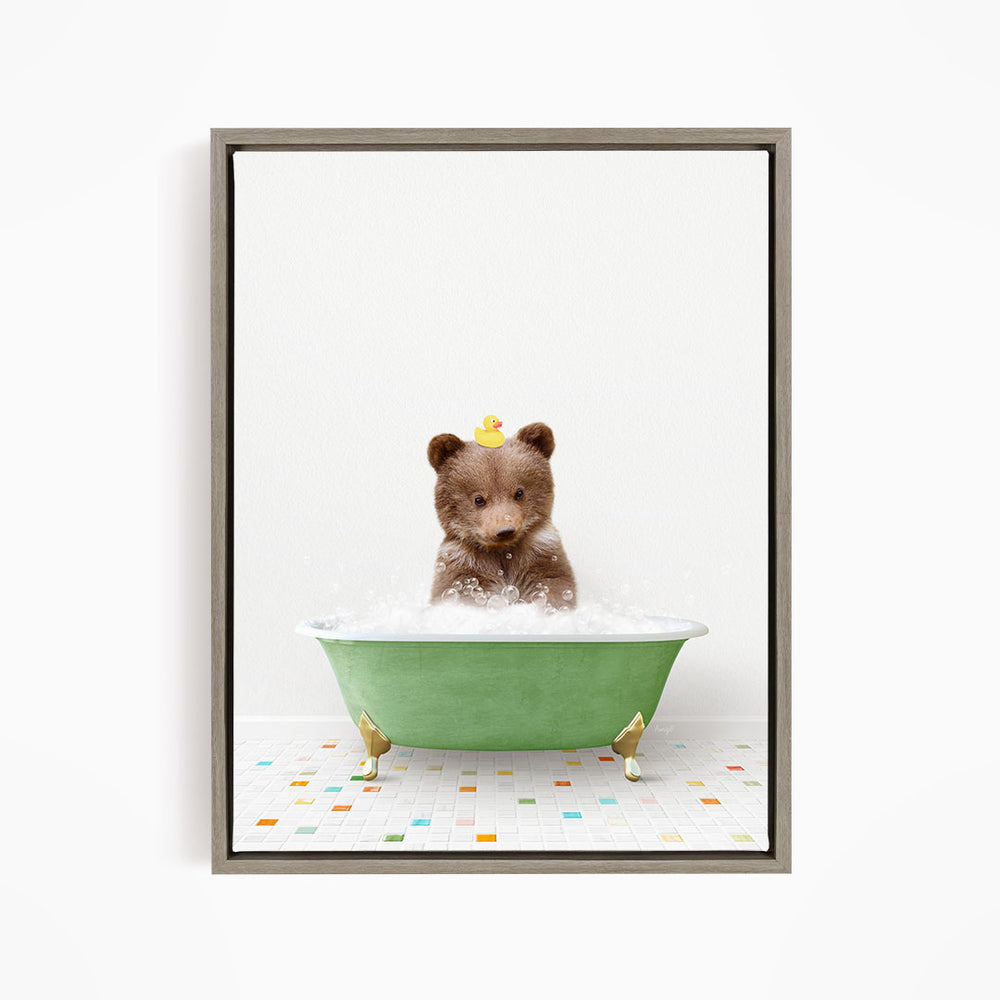 A cute brown bear sitting in a green bathtub filled with bubbles, with a yellow rubber duck floating on its head.