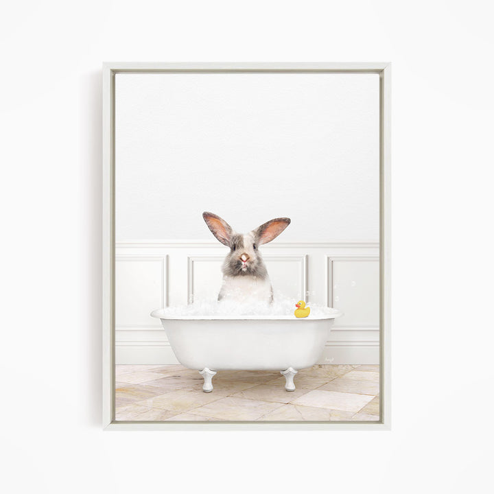 A white rabbit sitting in a white bathtub filled with water, with a rubber duck floating in the water.