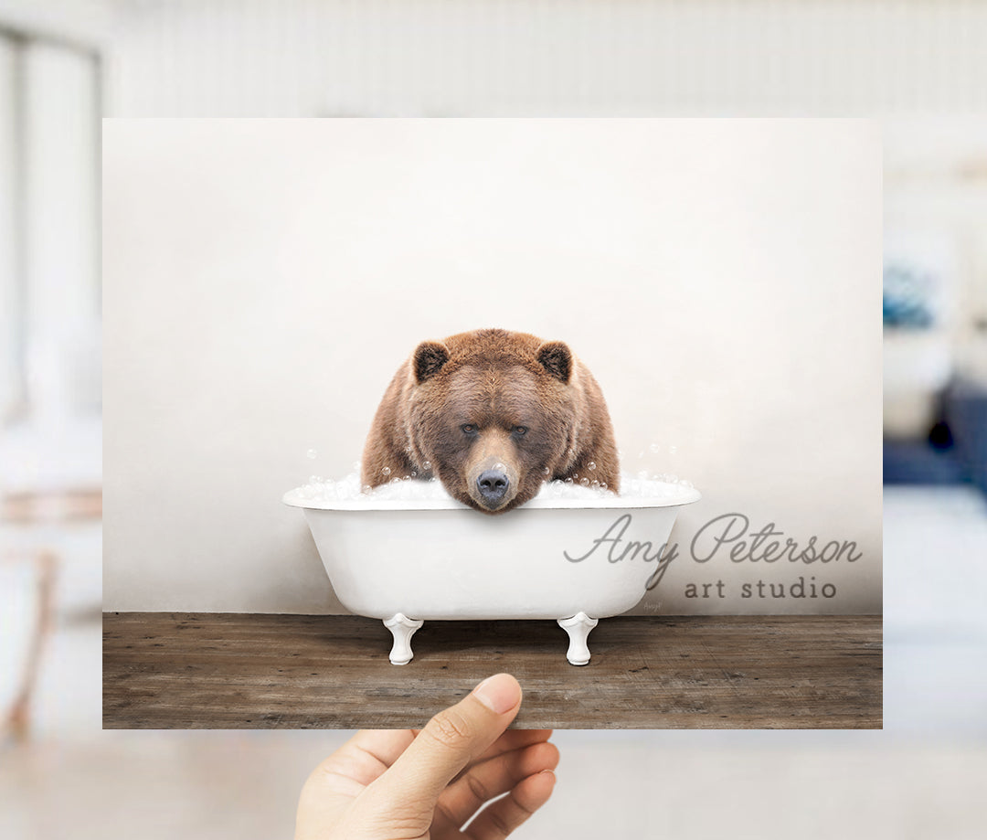 a person holding up a card with a bear in a bathtub