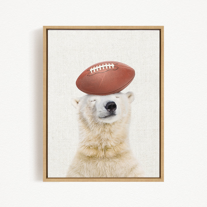 A polar bear balancing a football on its head.