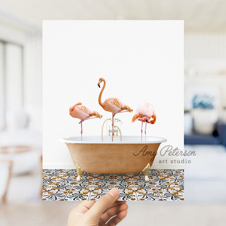 a person holding a card with three flamingos in a bathtub