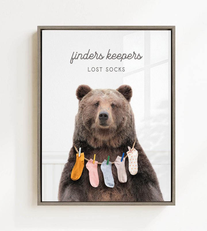 A large brown bear wearing a variety of colorful socks hanging from a clothesline.