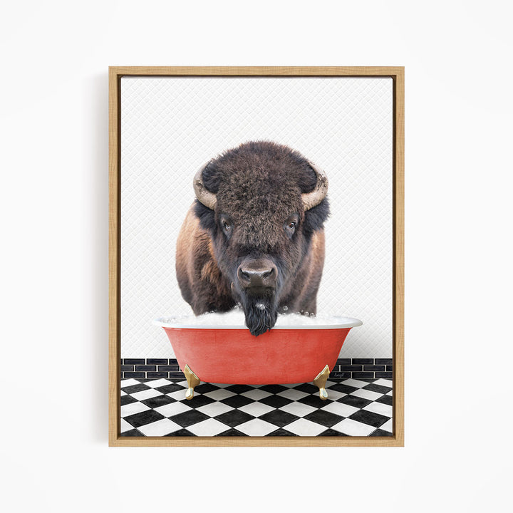 A buffalo with large horns is standing in a red bathtub filled with water, creating a whimsical and humorous scene.