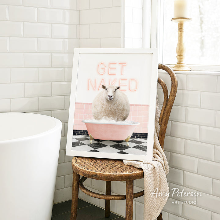 A framed image of a sheep sitting in a pink bathtub, with the text "GET NAKED" displayed on the frame.