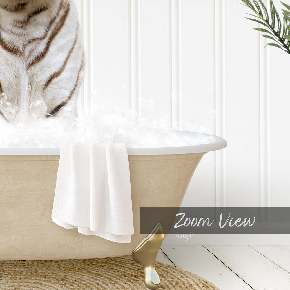 A cat sitting in a bathtub filled with bubbles, with a towel and a gold object nearby.