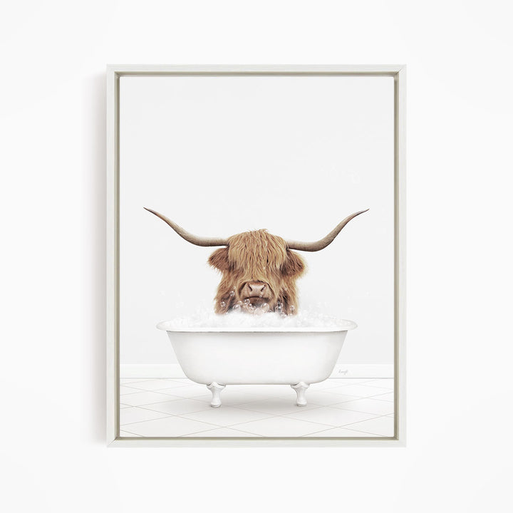 A brown cow with long horns is sitting in a white bathtub filled with water, appearing to enjoy the bath.
