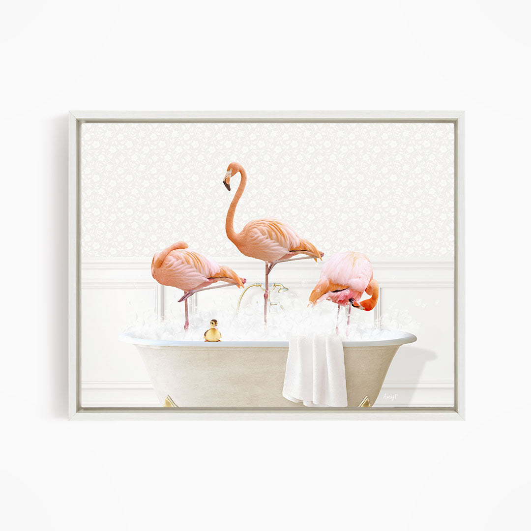 A framed image depicting three pink flamingos standing in a bathtub filled with water, with a small yellow duck floating on the water's surface.