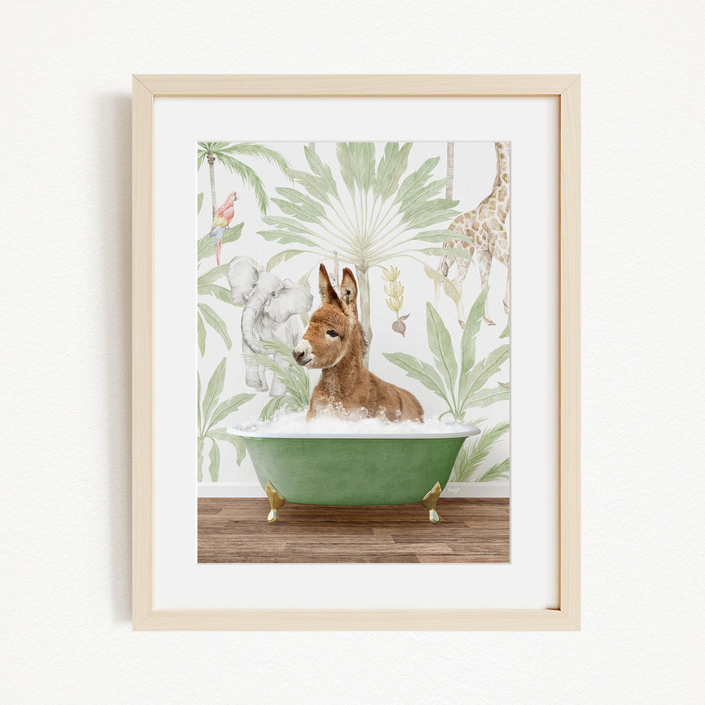 A framed illustration depicting a donkey sitting in a green bathtub, surrounded by a tropical jungle scene with various animals, including a giraffe and a kangaroo.