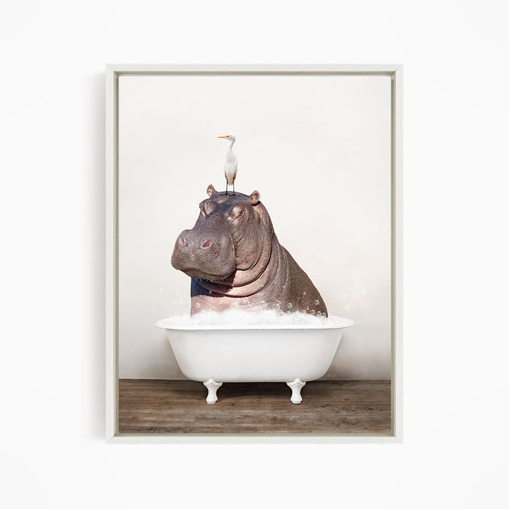A large hippopotamus is sitting in a white bathtub, with a seagull perched on its head.