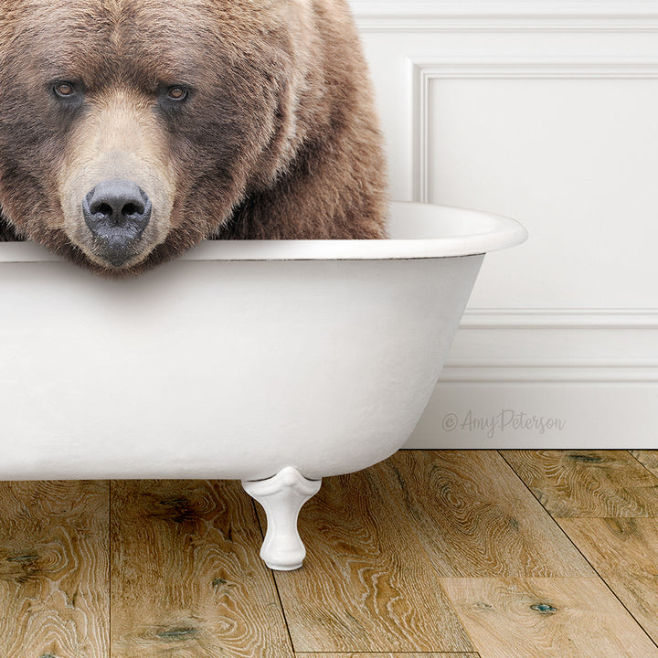 A large brown bear is sitting in a white bathtub, appearing relaxed and comfortable.