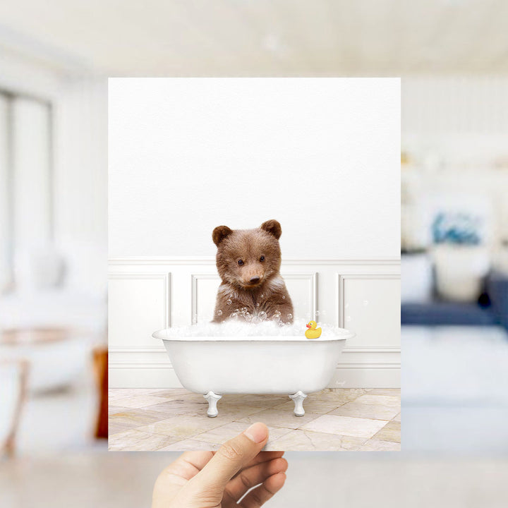A brown bear sitting in a white bathtub filled with bubbles, with a yellow rubber duck floating nearby.