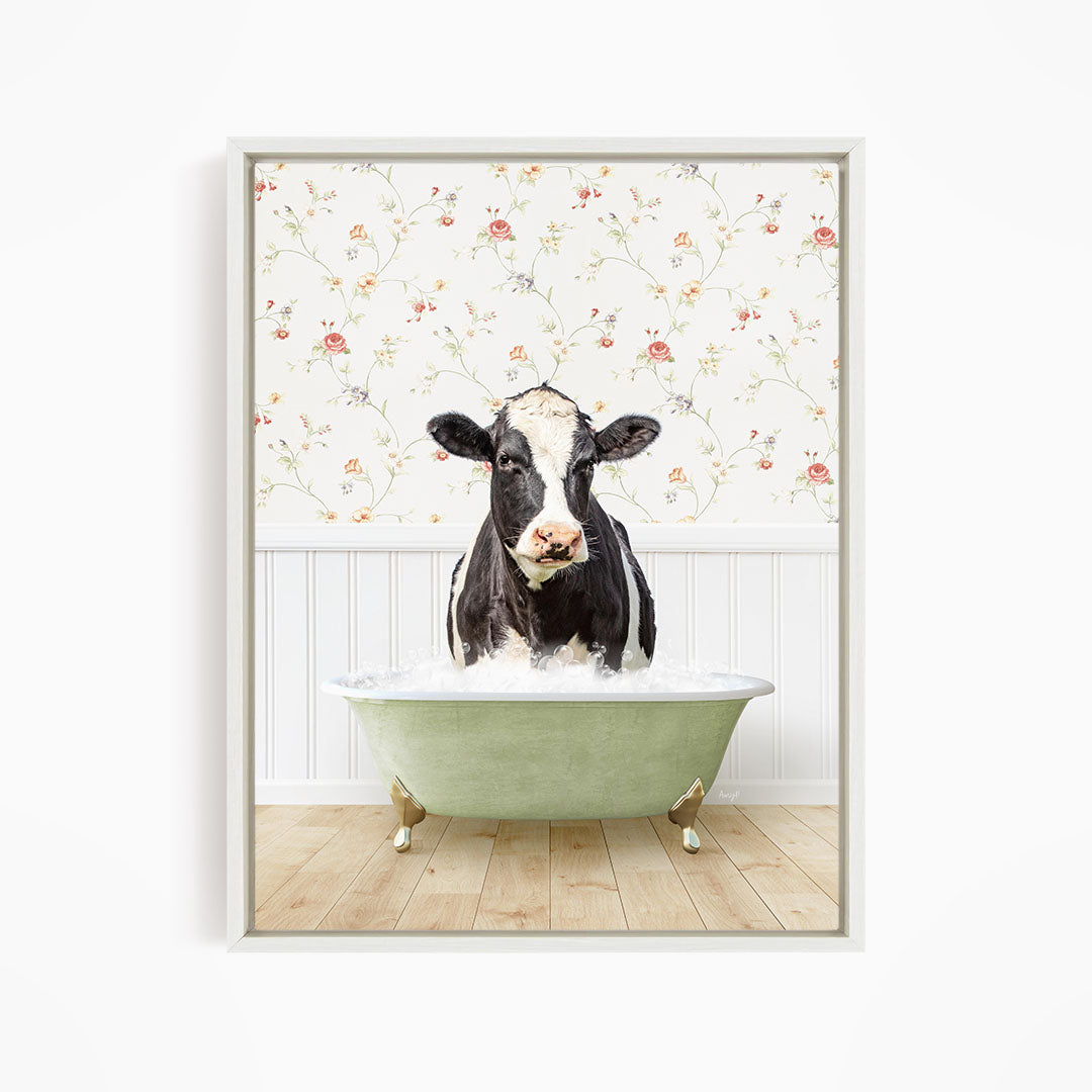 A black and white cow is sitting in a green bathtub filled with water, creating a whimsical and humorous scene.