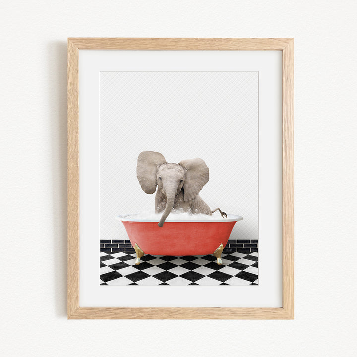A gray elephant is sitting in a red bathtub on a black and white checkered floor, with its trunk submerged in the water.
