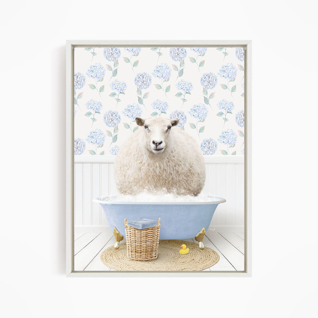 A fluffy white sheep sits in a blue bathtub filled with bubbles, surrounded by a wicker basket and yellow rubber ducks.