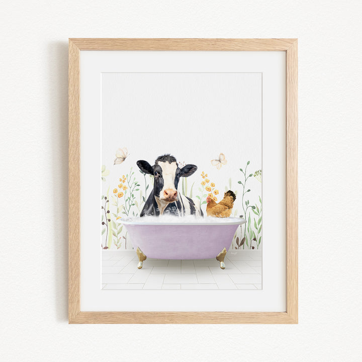 A framed print depicting a cow sitting in a bathtub filled with water, surrounded by flowers and butterflies.