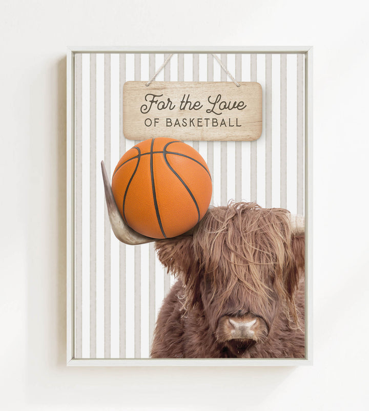 A framed image featuring a Highland cow holding a basketball, with a wooden sign above that reads "For the Love of Basketball".