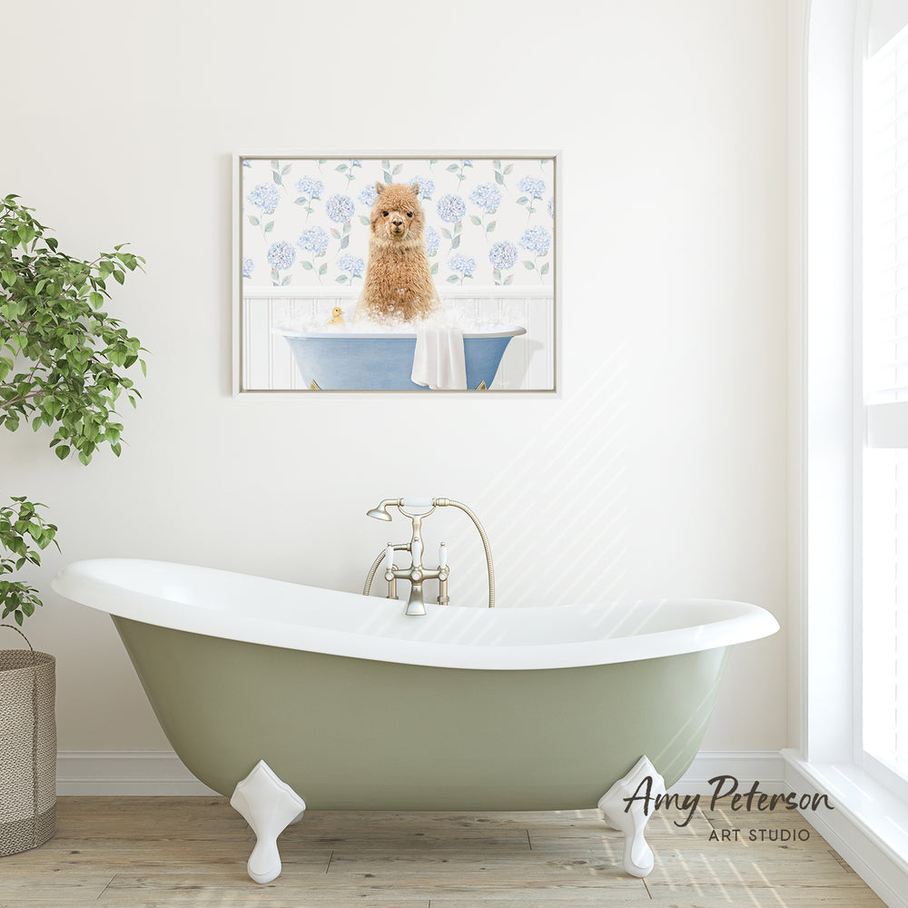 A framed image of a brown dog sitting in a blue bathtub, with a white towel draped over the side of the tub, is displayed on the wall above a green clawfoot bathtub in a bathroom.