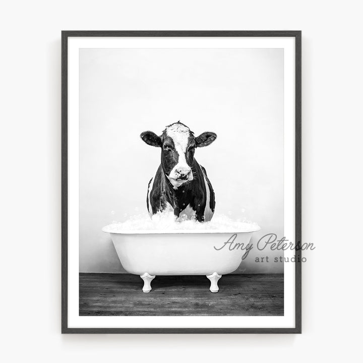 a black and white photo of a cow in a bathtub