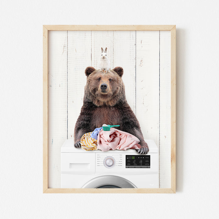 a brown bear sitting on top of a washing machine