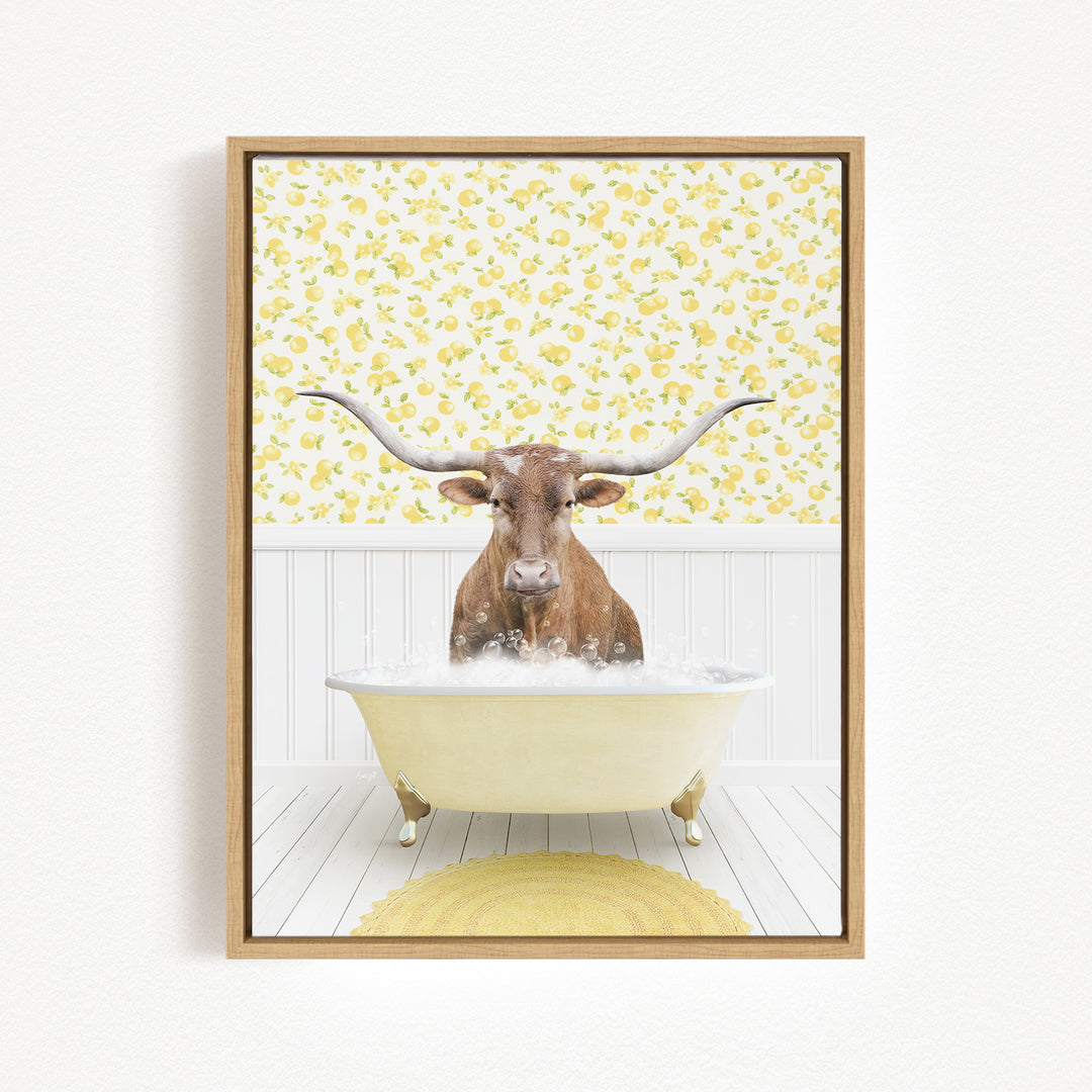 A brown steer with large horns is sitting in a white bathtub filled with bubbles, surrounded by a yellow floral pattern on the wall behind it.