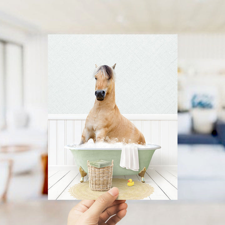 A brown horse sitting in a green bathtub filled with water, surrounded by a white towel and a yellow rubber duck.