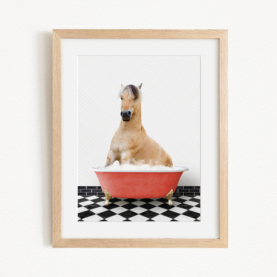 A light brown horse is sitting in a red bathtub filled with water, surrounded by a black and white checkered floor.