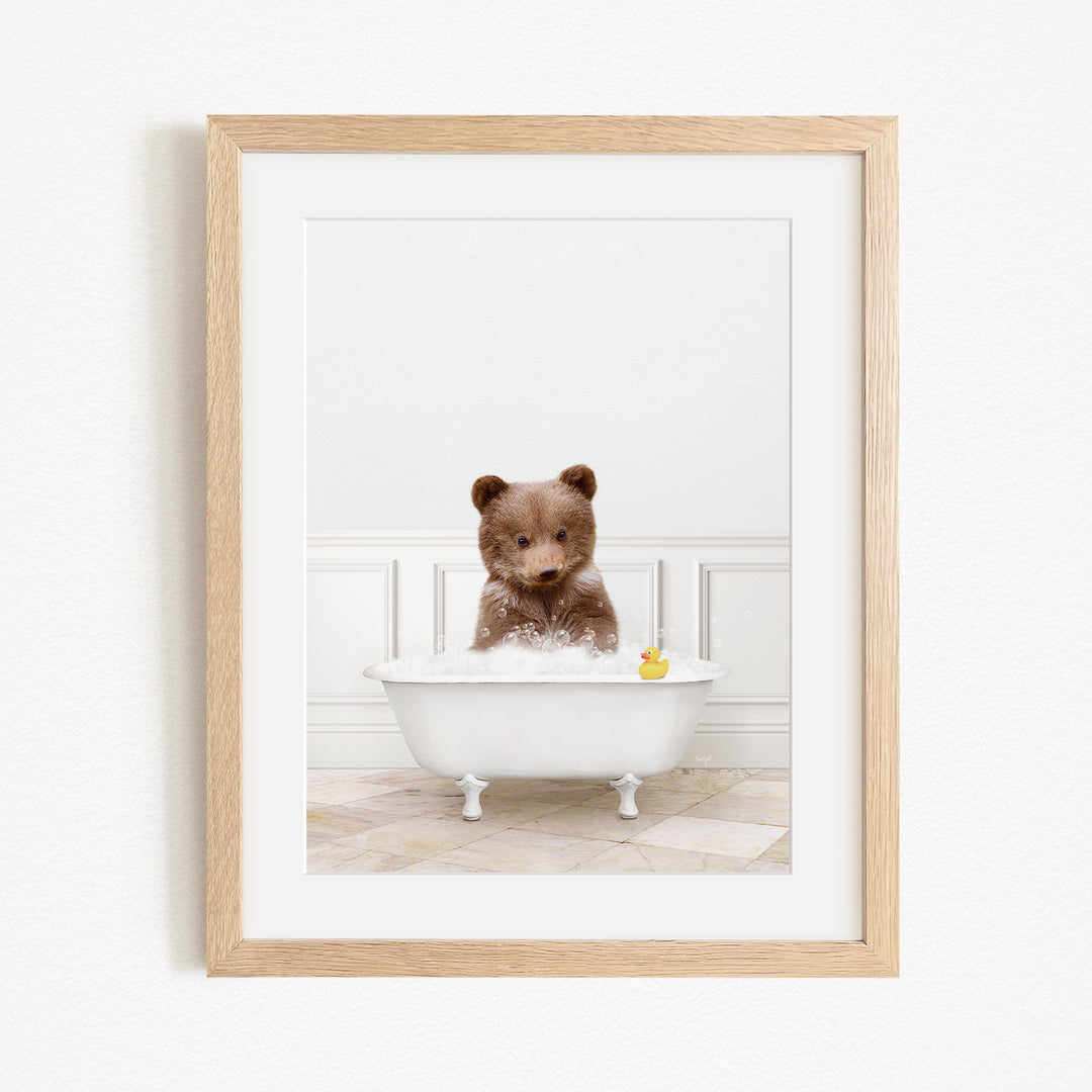 A brown bear sitting in a white bathtub filled with water, with a yellow rubber duck floating in the water.