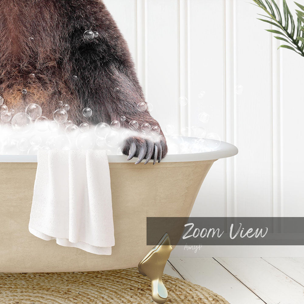 A close-up of a bear's paw in a bathtub filled with bubbles, with a towel and a gold object nearby.