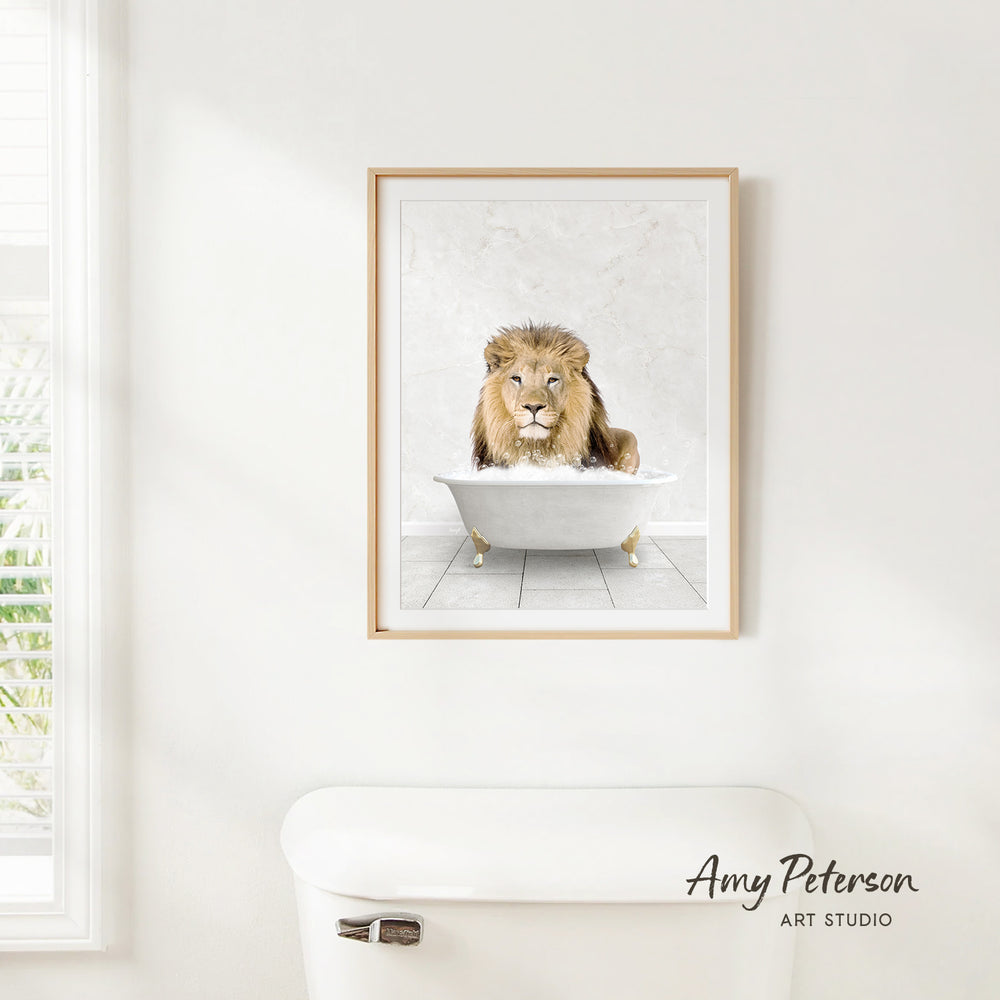 A framed image of a lion sitting in a bathtub is hanging on a white wall.