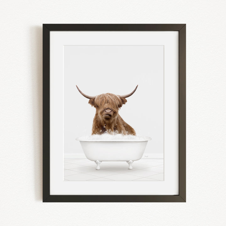 A brown Highland cow with large horns is sitting in a white bathtub filled with water, appearing to enjoy the bath.