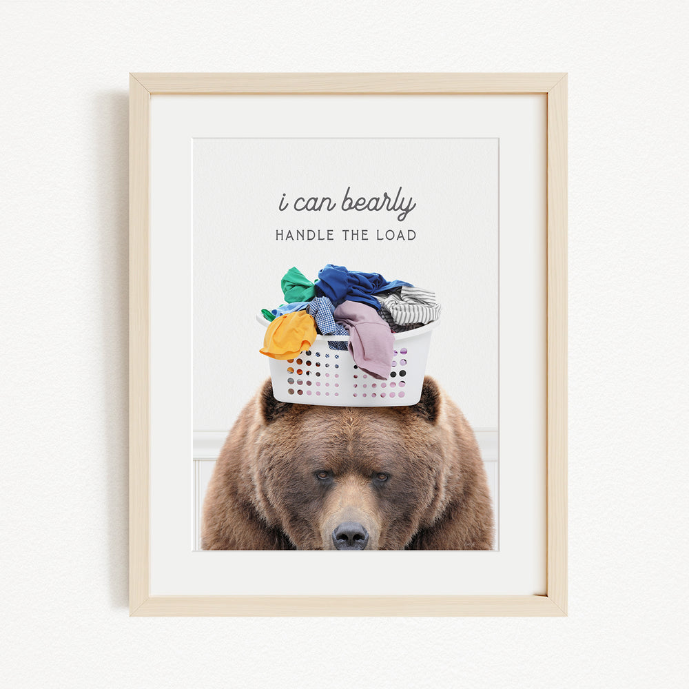 A brown bear with a laundry basket on its head, with the text "I can bearly handle the load" written above the basket.