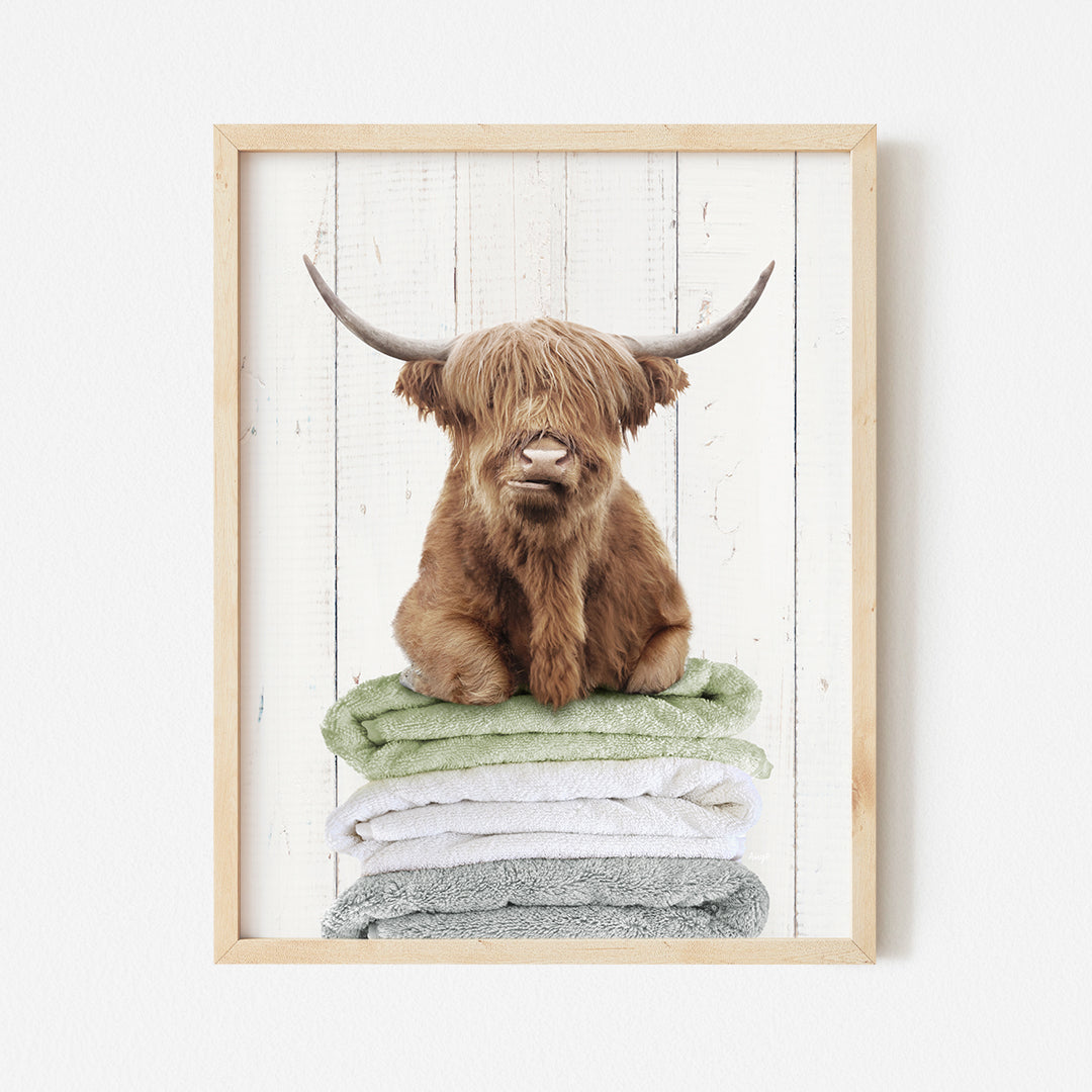 a picture of a brown cow sitting on top of a pile of towels