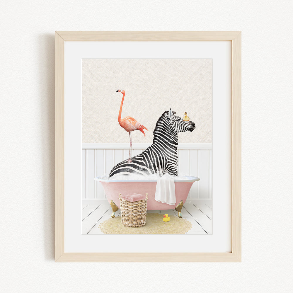 A framed image depicting a zebra sitting in a pink bathtub, with a flamingo standing on one leg and a yellow rubber duck floating nearby.